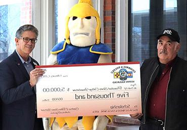 Scott Gibbs, the president of the Cumbres & Toltec Scenic Railroad presents scholarship check to James Kynoe, VP of the TSC Valley Campus